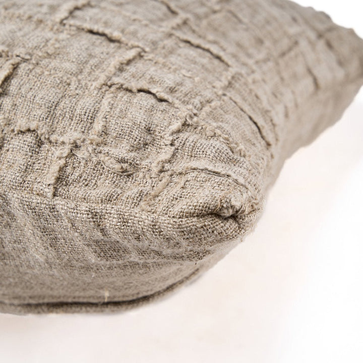 Textured beige pillow on a light background