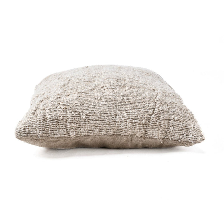Textured beige pillow on a white background