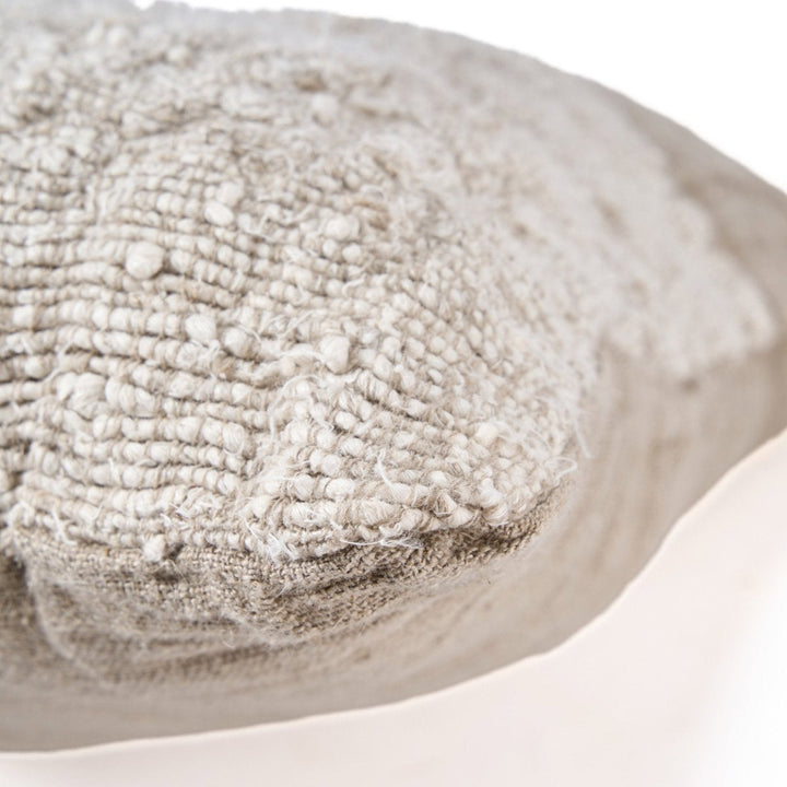 Close-up of a textured beige fabric pillow on a white background