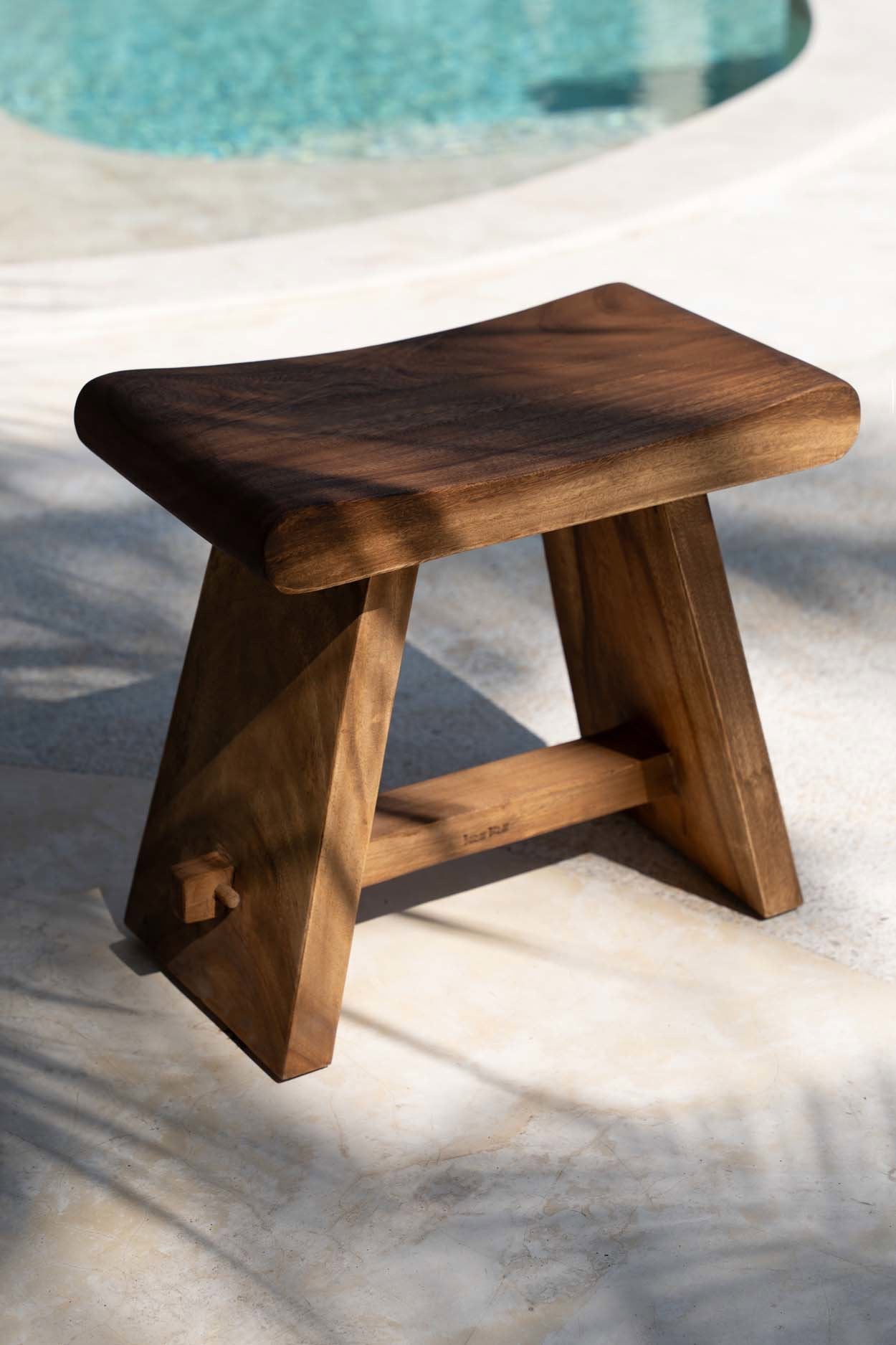 Wooden stool by a poolside