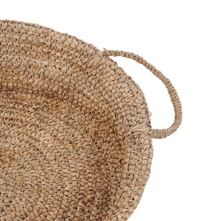 Close-up of a woven basket with a handle on a white background