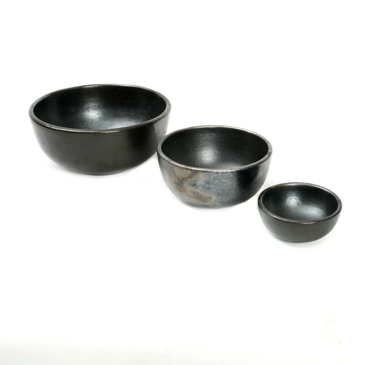 Three black ceramic bowls of different sizes on a white background