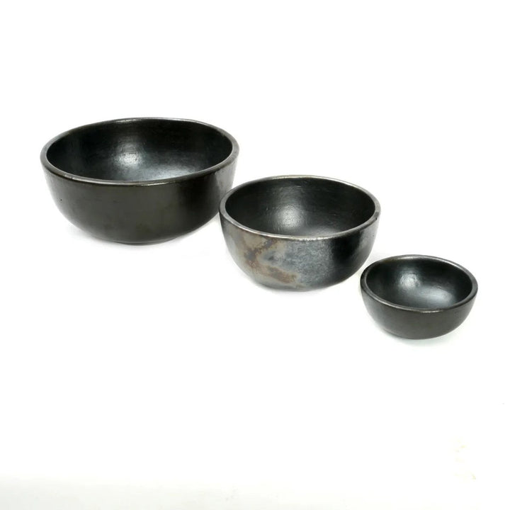 Three black ceramic bowls of different sizes on a white background