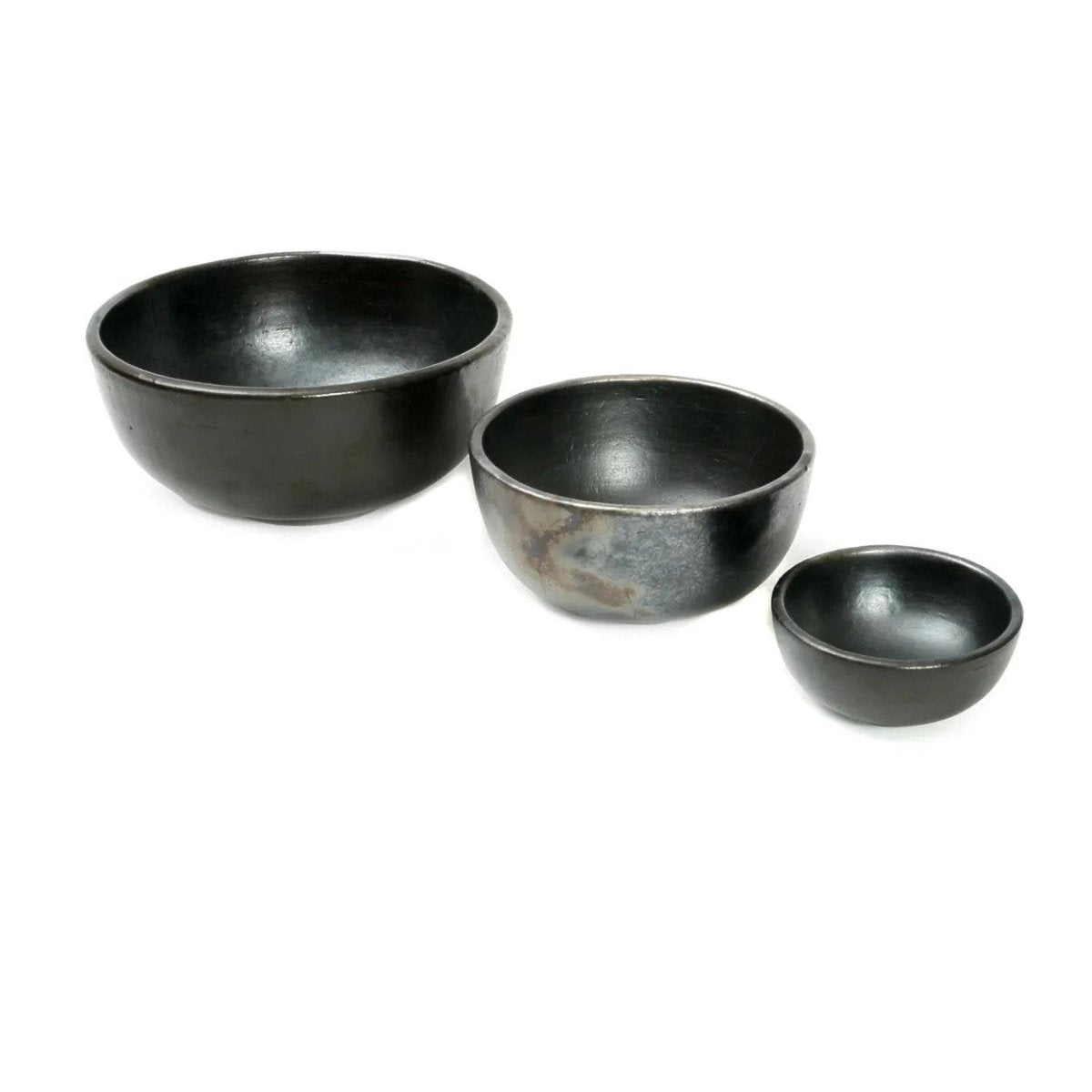 Three black ceramic bowls of varying sizes on a white background