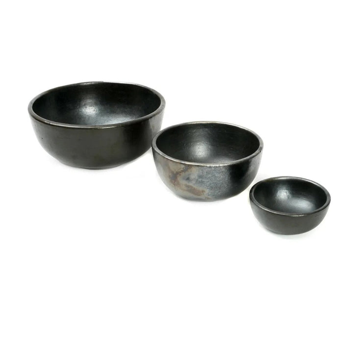 Three black ceramic bowls of varying sizes on a white background