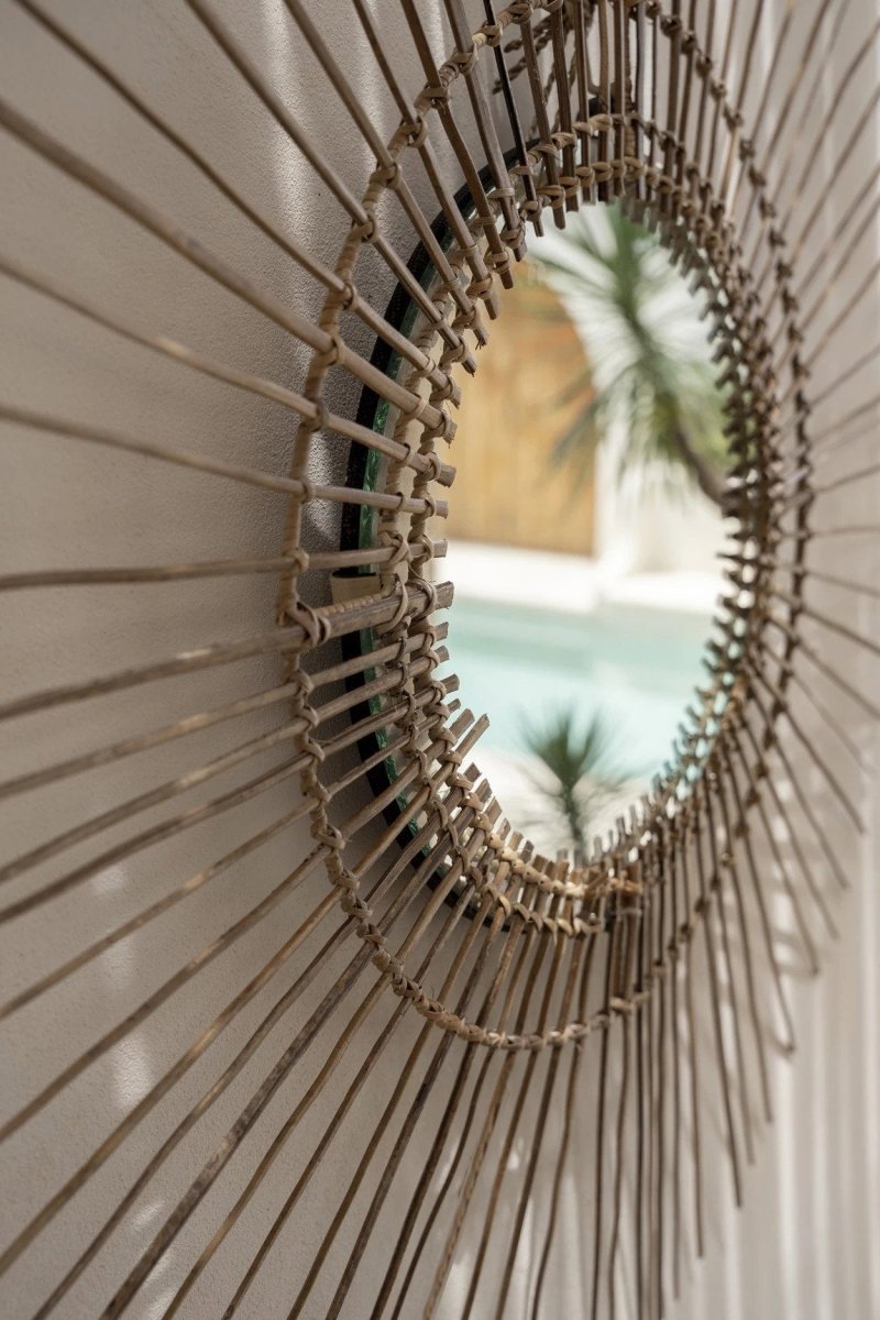 Round rattan mirror with blurred indoor background