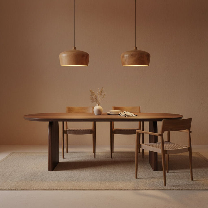 Dining area with wooden table and chairs under pendant lights in a warm-toned room.