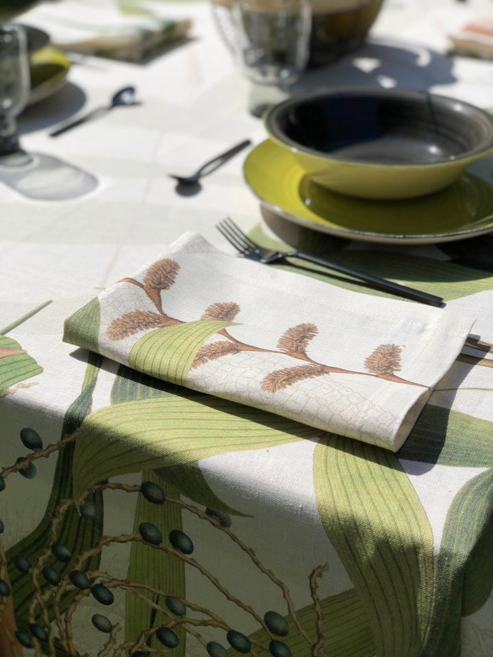 Table setting with a decorative tablecloth, napkin, and cutlery on a white table.