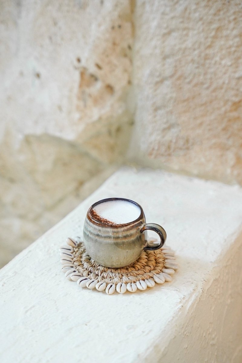 Ceramic mug with a dark rim on a textured surface