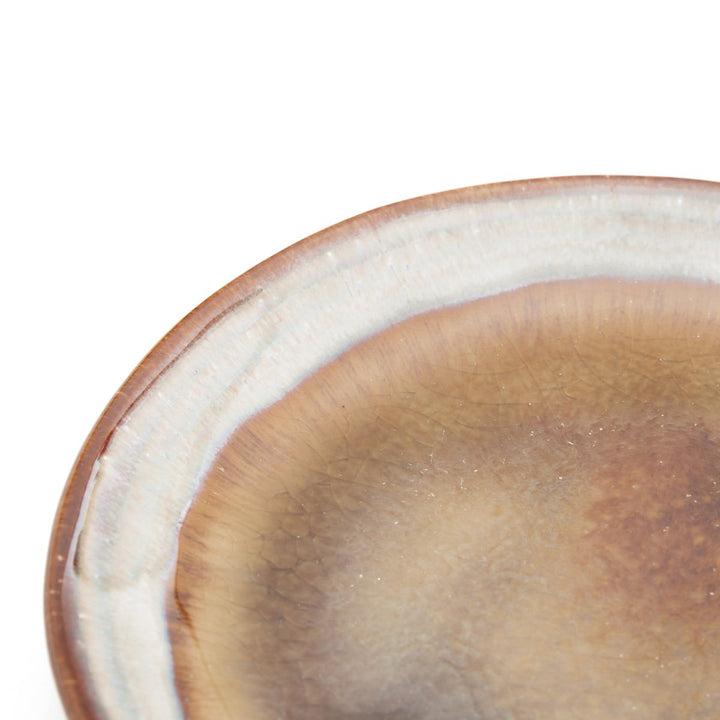 Close-up of a ceramic plate with a white rim on a white background