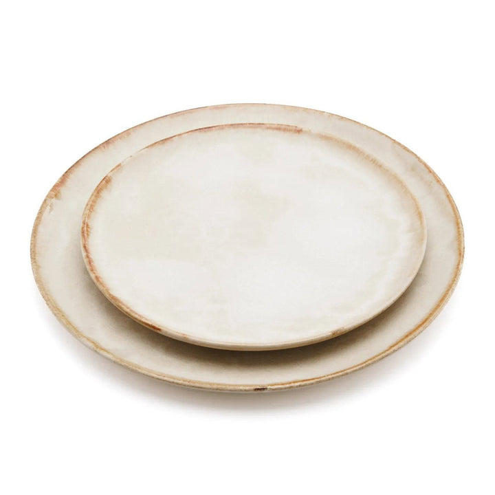 Stack of ceramic plates with a rustic finish on a white background