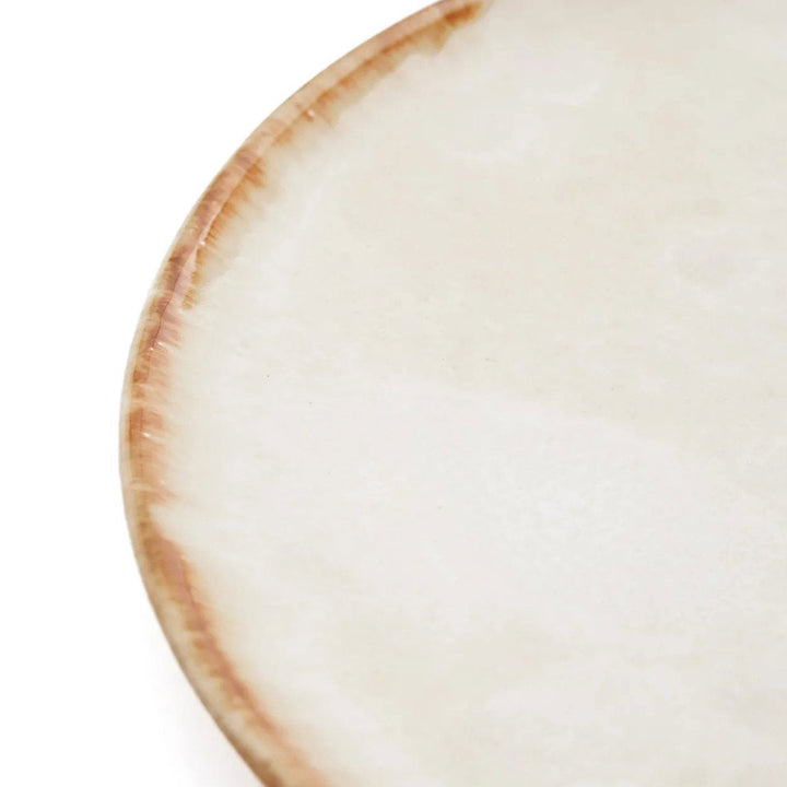 Close-up of a ceramic plate with a brown rim on a white background