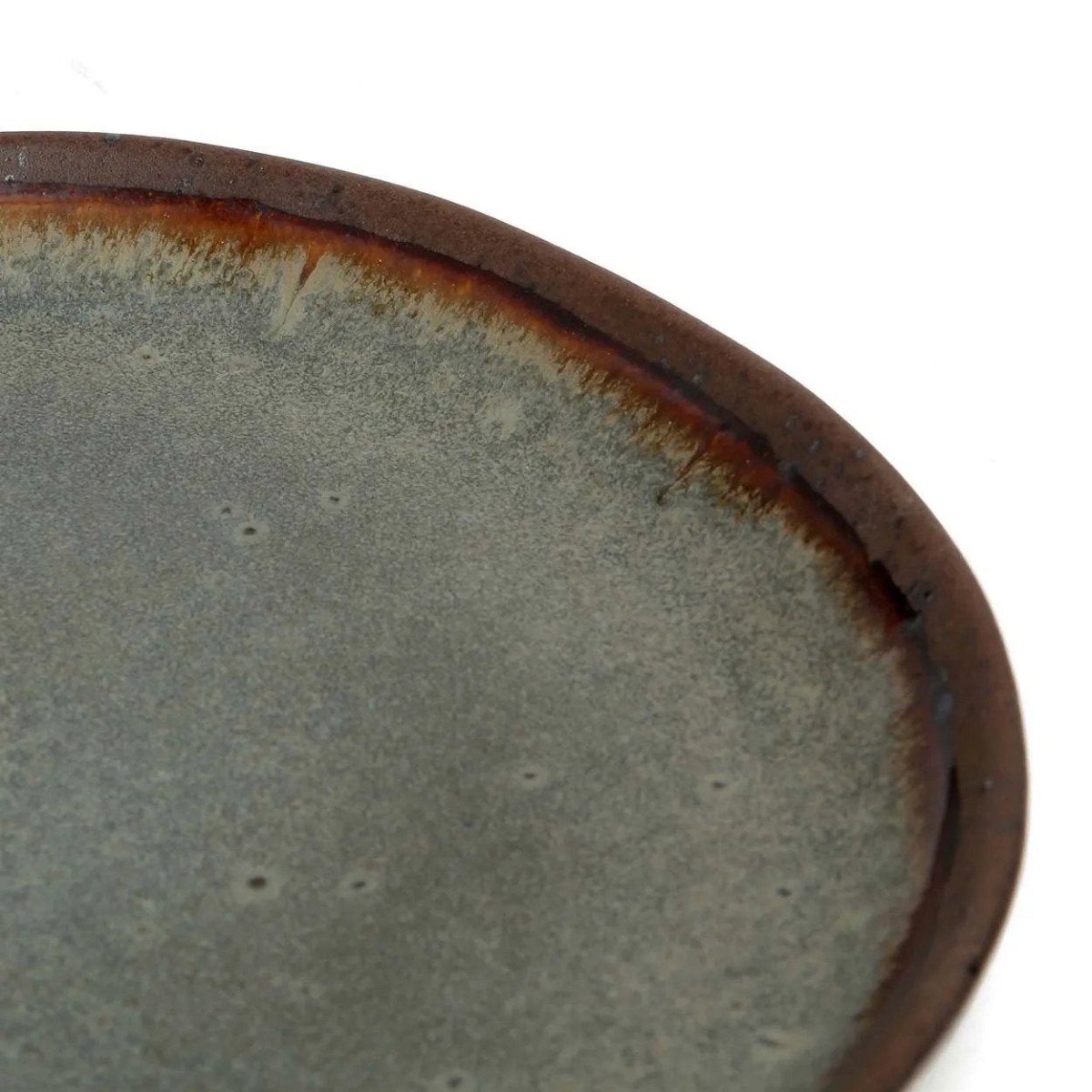 Close-up of a ceramic plate with a brown rim on a white background
