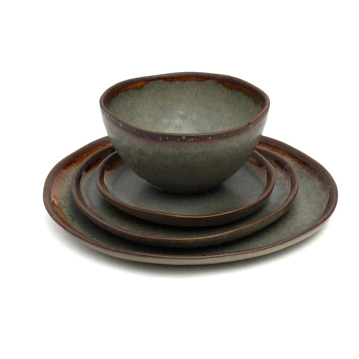 Set of ceramic bowls and plates with a rustic finish on a white background