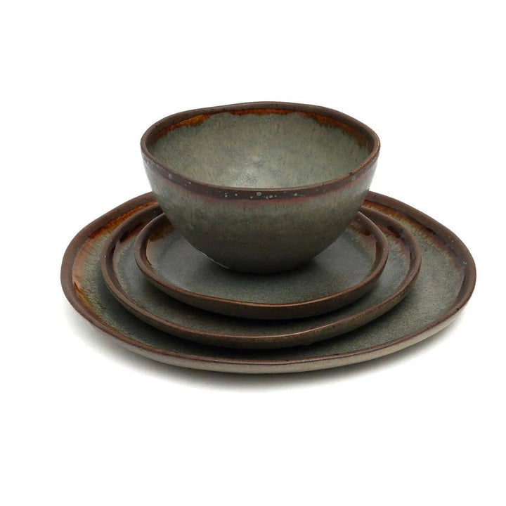 Set of ceramic bowls and plates with a rustic finish on a white background