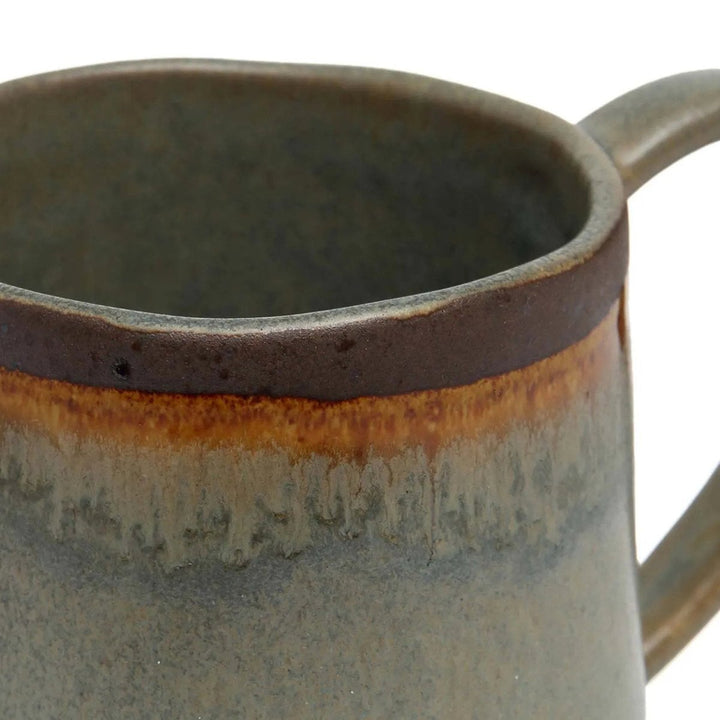Close-up of a ceramic mug with a textured surface and gradient color.