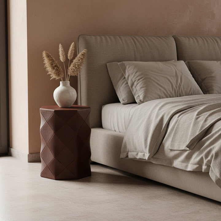 Neatly made bed with beige bedding and pillows in a bedroom setting.