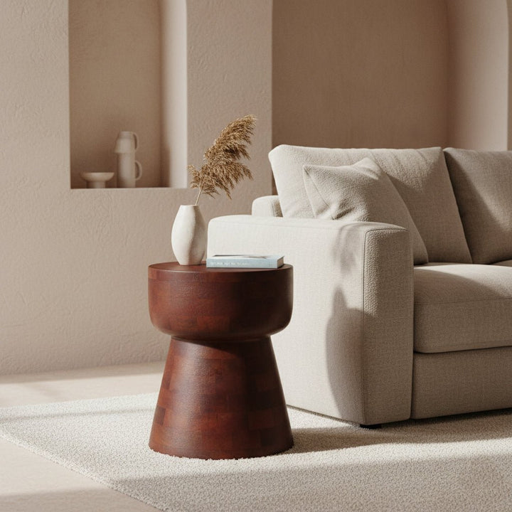Beige sofa with a wooden side table and decorative items in a minimalistic living room.