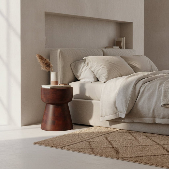 Modern bedroom with a bed, side table, and decorative elements.