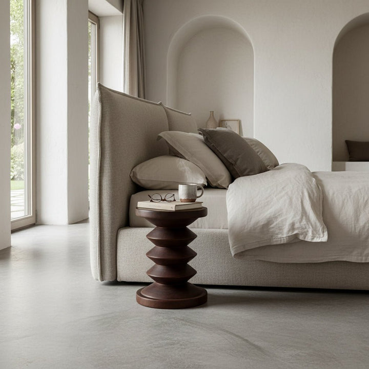 Modern bedroom with a bed, side table, and large windows.