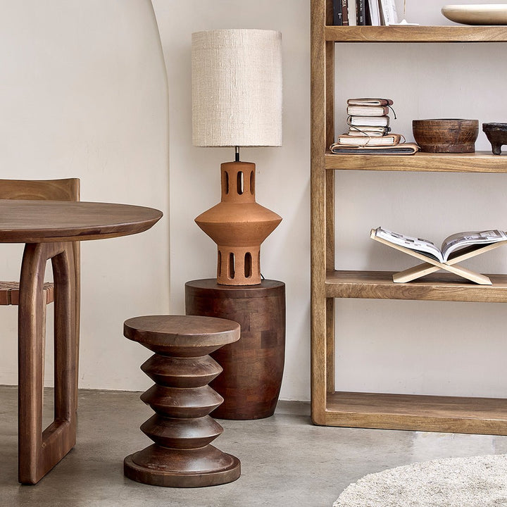 Wooden furniture including a table, stool, and shelf with decorative items in a room setting.