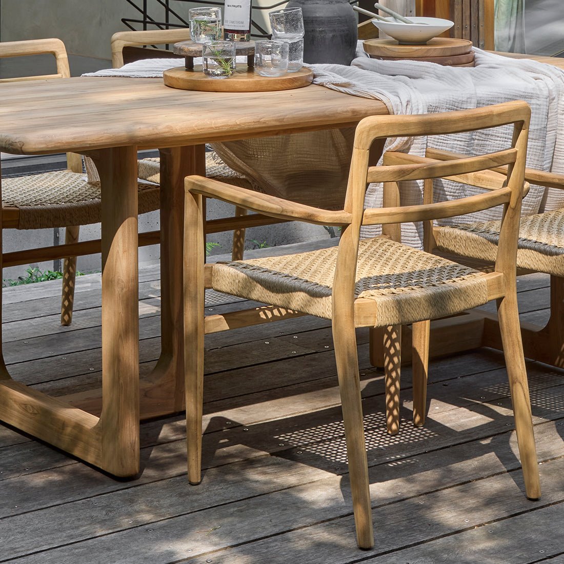 Wooden outdoor dining table with chairs on a deck