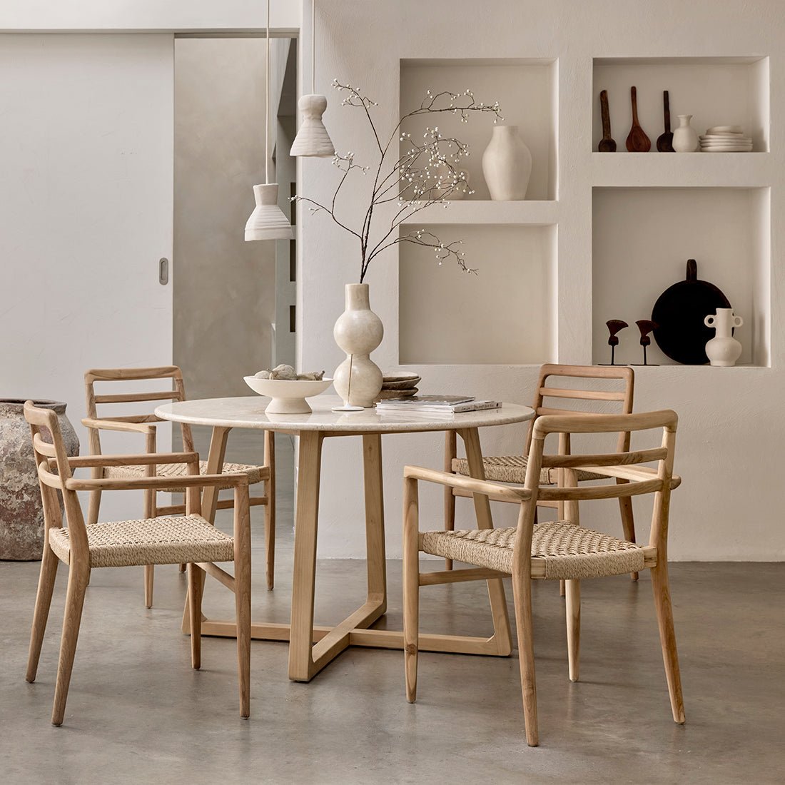 Dining area with a round table and four chairs in a modern interior setting.