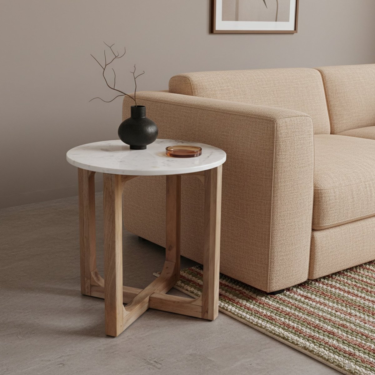 Beige sofa with a round wooden side table featuring a black vase and small dish in a living room setting.