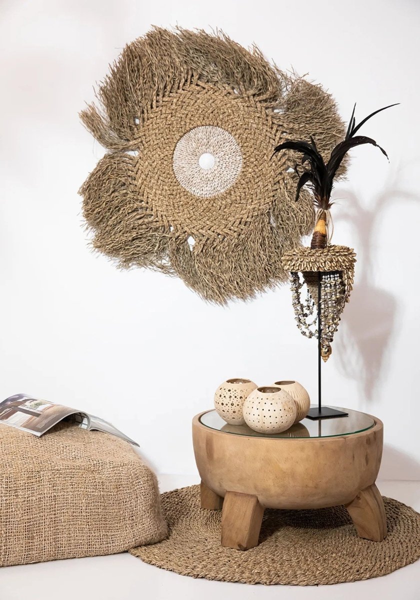 Decorative jute wall art with a wooden table and decorative items on a white background