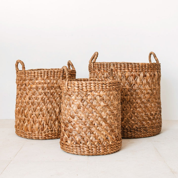 Three woven baskets of different sizes on a light background