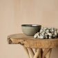 Comporta Cornflakes Bowl 15cm on wooden table, showcasing artisanal crackle glaze in greenish blue tones.