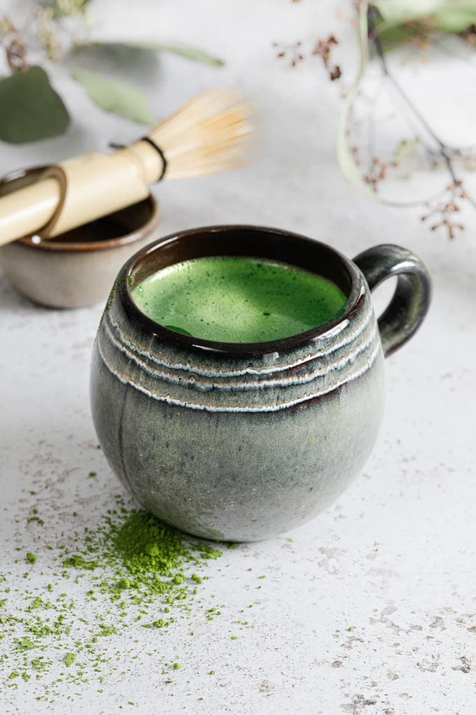 The Comporta Coffee Cup - L with green beverage, part of a meticulously crafted set of 6, adding elegance and charm to your table.