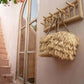 Island Coat Rack made of natural teakwood, mounted on an indoor wall, holding a decorative straw bag.