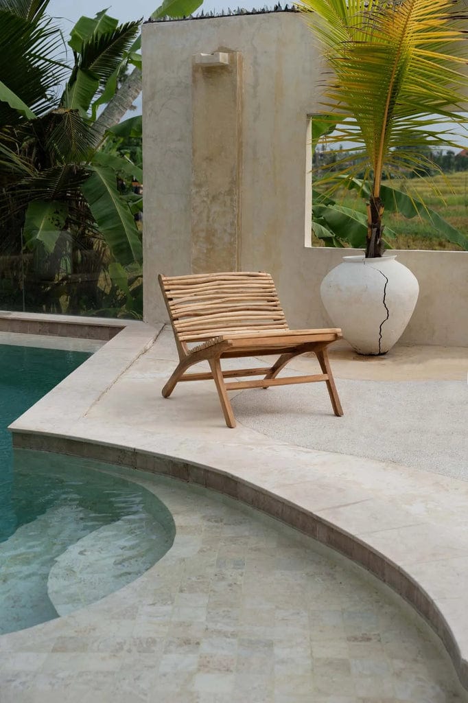 Handcrafted teak wood chair next to a pool, Islander Eenzit - Natural design.