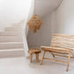 Handcrafted teak wood chair, Islander Eenzit - Natural, in minimalist indoor setting.