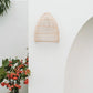 Lalo Wall Lamp - Natural, rattan sconce on white wall, cone shape, outdoor setting.