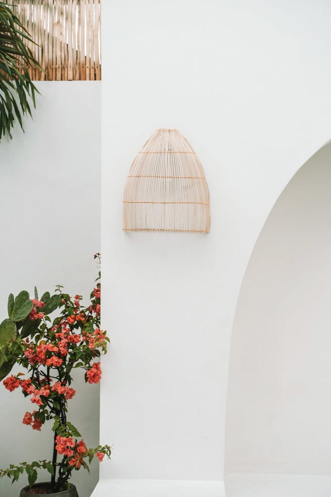 Lalo Wall Lamp - Natural, rattan sconce on white wall, cone shape, outdoor setting.