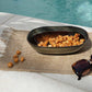 Comporta Oval Bowl 25cm displayed by a pool with sunglasses and snacks.