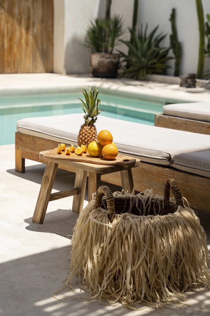 Quincy Stool made from natural reclaimed teak by a poolside setting.