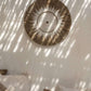 Raffia Macramé Wall Decoration in white and natural tones hanging on a wall, adding bohemian and coastal charm.