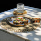 Seagrass shell placemat with cowrie shell border on dining table.