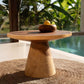 Seagrass rug in natural hue, 100cm round, under a wooden table by a pool.