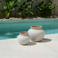 Styly Vase in natural concrete with raffia detail by a poolside.