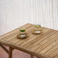 Tulum Coffee Table in teak wood on outdoor patio with two drinks.