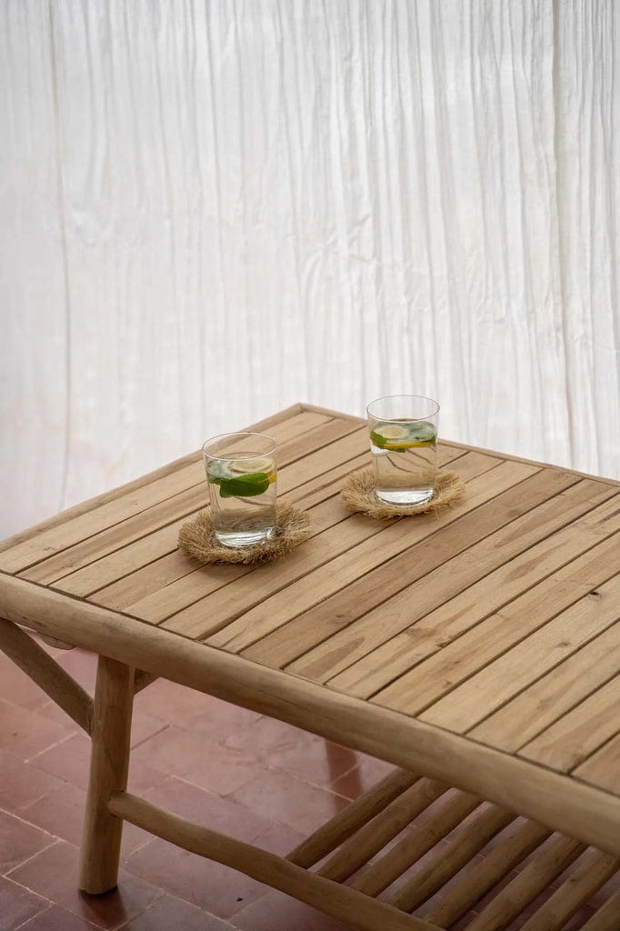 Tulum Coffee Table in teak wood on outdoor patio with two drinks.