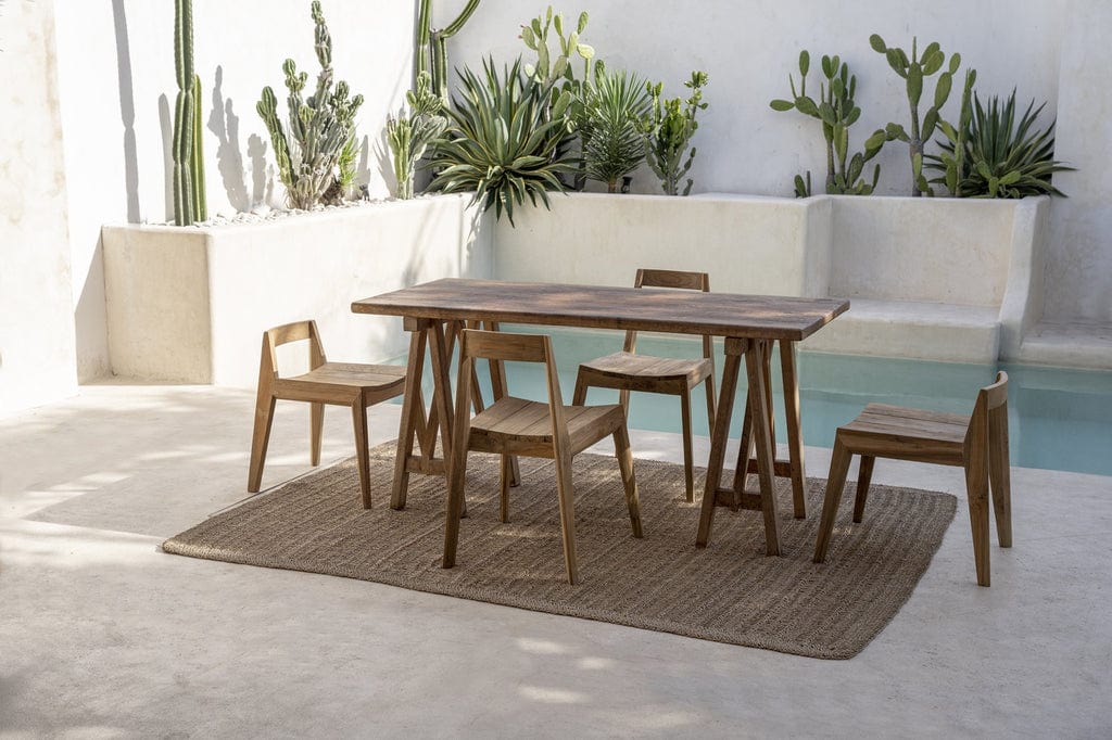 Ydra Dining Chair - Natural - Outdoor next to a pool with a teak dining table and desert plants in the background.