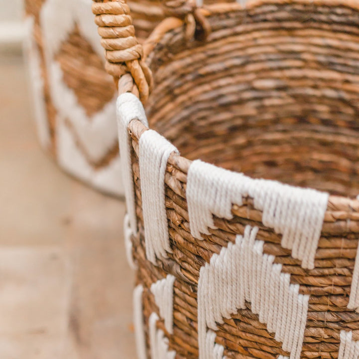 Close-up of a woven basket with decorative white accents on a blurred background