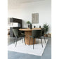 Dining area with round wooden table, green chairs, and Erba banana leaf baskets in the corner for decor.