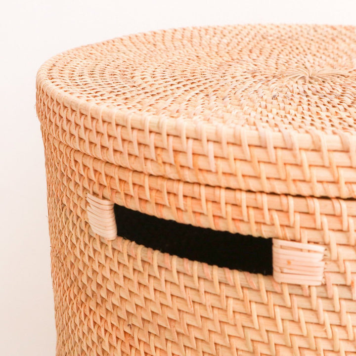 Woven basket with a black handle on a light background