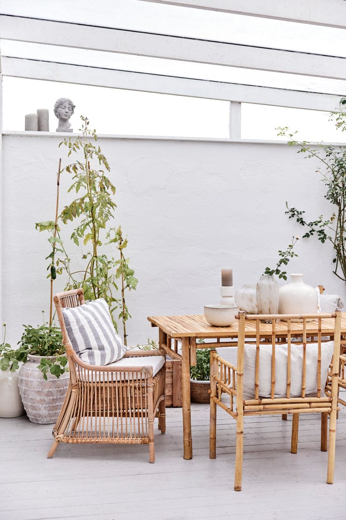 Norah handwoven rattan dining chair showcasing sustainable and natural design in a stylish patio setting.